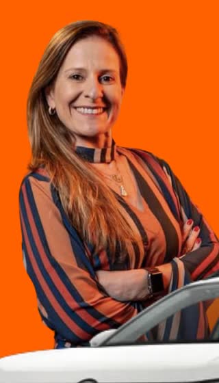 Consultora da Valen Seguralta sorrindo ao lado de um carro